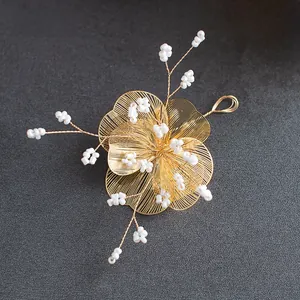 Détail d'épingle à cheveux fleur dorée avec perles blanches pour coiffure mariée