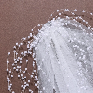 White bridal veil with soft mesh, pearl chains, and rhinestone detail for wedding hair