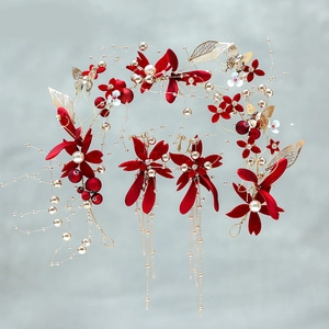 Detail of red velvet bridal headpiece and gold tassel earrings with pearl flower accents
