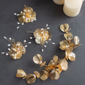 Elegante gouden bruidshaaraccessoires set met metalen bloemen en witte parels details