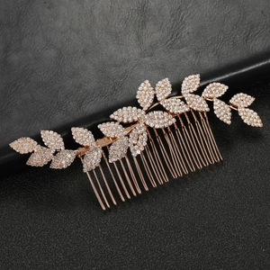Macro view of rose gold leaf hair comb with sparkling rhinestones on black background