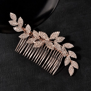 Elegant rose gold bridal hair comb with rhinestone leaves on black leather background