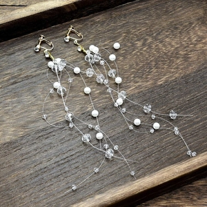 Elegante gouden bruids oorbellen met lange witte parel en kristallen kwastjes op hout