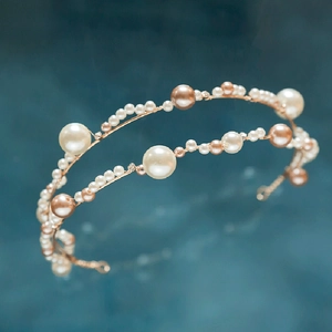Champagne gold pearl bridal headband set with rhinestones on a blue textured background