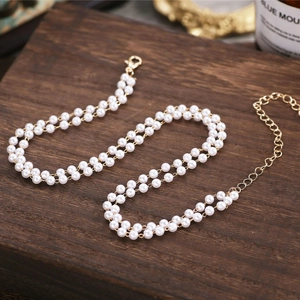 Close-up of double-layer pearl necklace with golden lobster clasp on a wooden surface
