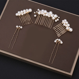 Detail of 5-piece bridal hair set with handmade pearls on golden metal combs and hairpins