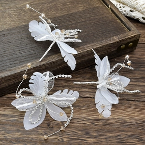 Handgemaakte libelle haarspelden met witte vleugels en kristallen op vintage houtwerk