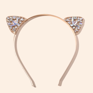 Détail d'un serre-tête oreilles de chat en or rose orné de strass brillants variés