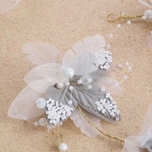 Exquisite bridal hairband set with blue leaves, pearls, and rhinestones on cork background