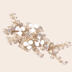 Close-up of bridal gold leaf hair comb with white flowers and crystal beads detail