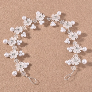 Silver bridal hair vine with frosted white flowers, pearls and crystal beads on textured background