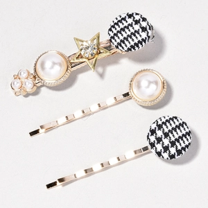 Detail view of a 3-piece vintage pearl hair clip set with houndstooth and golden alloy