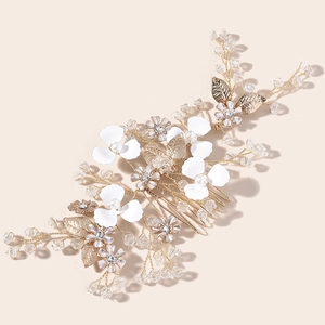 Detail view of handmade bridal hair comb with gold metal leaves and pearl flowers