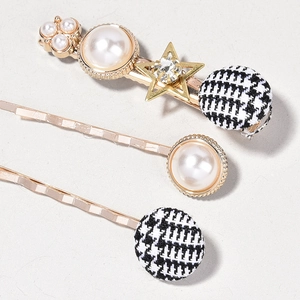 Detail showing gold hair clip set with pearls, stars, and houndstooth fabric spheres