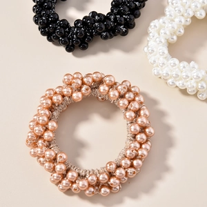 Détail de chouchous en perles de couleurs noir, blanc et or champagne élégants