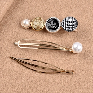 Detailed set of three gold-tone hair clips with faux pearls and crown crest button charms