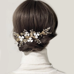 Elegant bridal hair comb with gold leaves, white flowers and crystals for wedding hairstyle