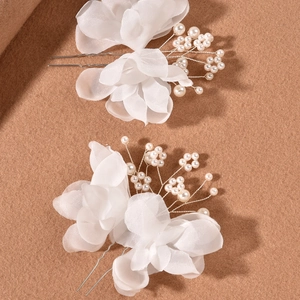 Detail of white gauze flower hair pins with pearls for bridal wedding hairstyles