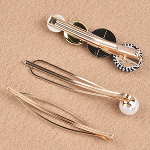 Detail of three-piece vintage pearl hair clips set with gold alloy and houndstooth pattern