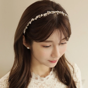 Detail of elegant handmade pearl headband with gold wire weaving on a female model