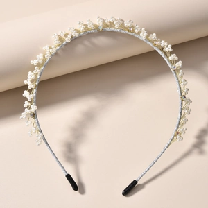 Elegant handmade pearl headband with crystal accents on a minimalist display