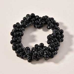 Gros plan détaillé d'un élastique à cheveux noir orné de perles rondes polies brillantes
