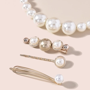 Detailed view of elegant gold hair clips with polished pearls in varied sizes