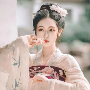 Close-up of floral embroidery on traditional hanfu dress with pink silk flower hair accessories