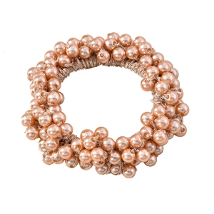 Détail d'un élastique à cheveux avec perles dorées champagne et texture tissée