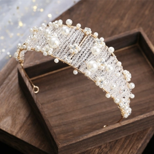 Close-up of handmade bridal crown with white pearls and crystals on a gold wire