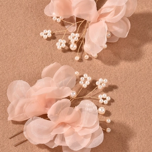 Detail of pink organza flower hair pins with pearls and golden metallic u-shaped base