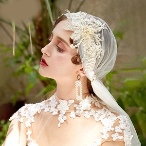 Close-up of white bridal veil with 3D lace flowers, delicate embroidery and pearls