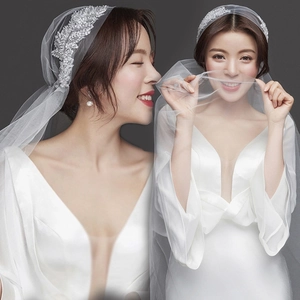 Detail of elegant double-layer white bridal veil and silver leaf rhinestone hairclip set