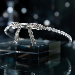 Dettaglio del cerchietto da sposa scintillante con fiocco di strass su sfondo scuro