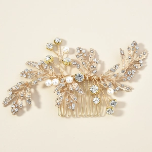 Detailed view of bridal hair comb with golden alloy leaves, white pearls and crystals