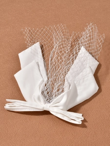 Détail d'un nœud en satin blanc avec voile en résille élégant sur fond marron