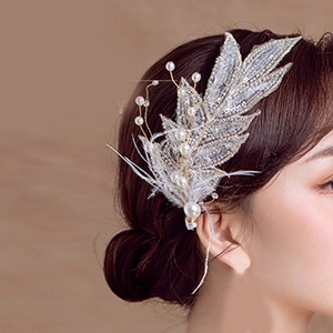 Detail of handmade bridal hair clip featuring white pearls sequins and soft feather leaves