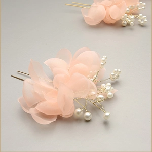Detail of elegant bridal hair pin with pink tulle petals and delicate white pearls