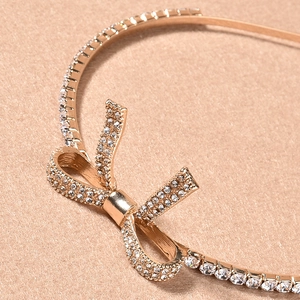 Dettaglio macro del cerchietto da sposa in oro rosa con fiocco di strass e castone a griffe
