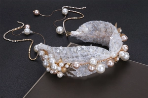 Detail of bridal headband with white sequins, champagne pearls and golden metal flowers