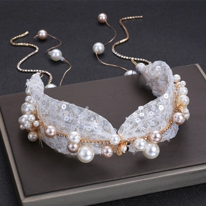 Close-up of bridal headband with sparkling sequins, pearls, and gold tassel details