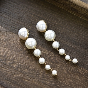 Elegant long gold drop earrings with six graduated white pearls for wedding bridal style