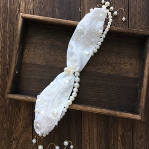Detail of vintage bridal hairband featuring white pearls, sequins and satin embroidery