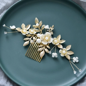 Vue détaillée du peigne à cheveux de mariée avec fleurs blanches et perles sur fil doré
