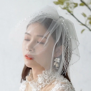 Detail of elegant short white bridal veil with shimmering sequin trim and layered tulle