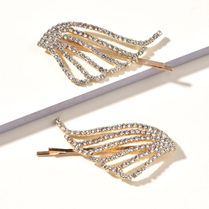 Detailed close-up of two golden wing-shaped hairpins with shimmering inlaid rhinestones
