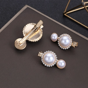 Detailed close-up of champagne gold hair clips with white pearls and sparkling rhinestones