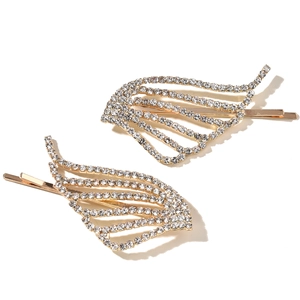 Detailed macro view of two gold angel wing hair pins with sparkling white rhinestones