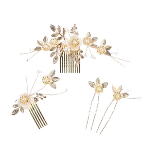 Parure d'accessoires de mariée avec feuilles dorées, perles et cristaux sur fond blanc