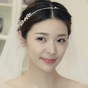 Detail of bridal headband with crystal leaves, pearls and elegant white tulle veil